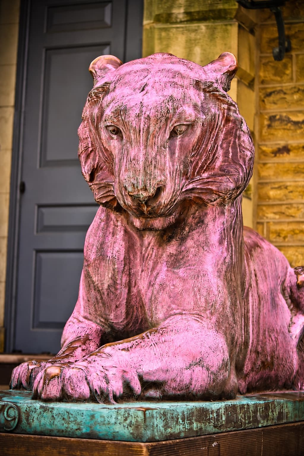 Pink-tinted bronze tiger statue at Princeton, with a hue slider along the grass